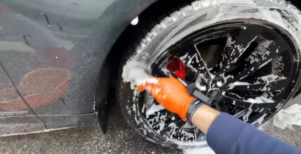 Cleaning a car tyre and wheel during an exterior detail