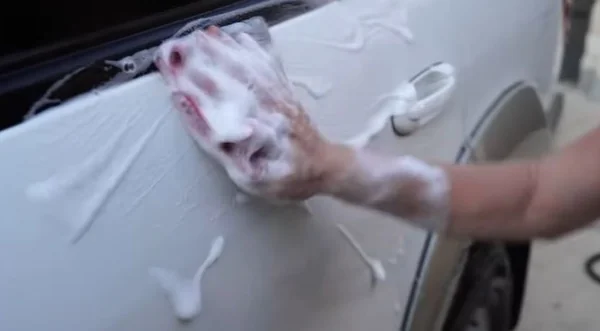 Wiping a car panel with a synthetic towel