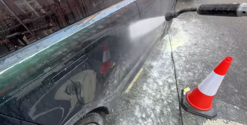 Rinsing a car with clean water after washing
